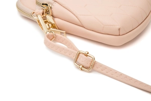 Detail der rosa Handy-Umhängetasche mit gestepptem Rautenmuster und goldenem Zipper