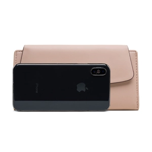 Detailed view of pink long wallet with lychee leather texture and iPhone for scale