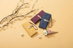 Detailed view of matte PU leather wallets in yellow, red, and blue with wrist straps