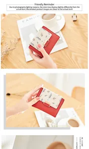 Close-up of red and beige bicolor PU leather wallet with floral print and gold buckle