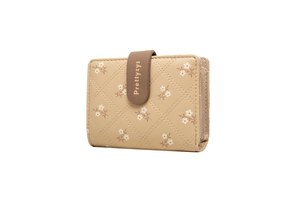 Detail view of beige PU leather wallet with quilted pattern and floral print accents
