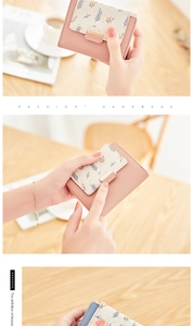 Detail of a pink and white patchwork PU leather wallet featuring leaf prints and a gold lock