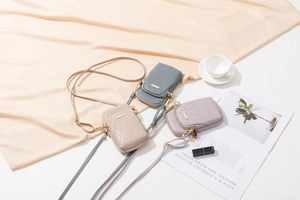 Detailansicht gesteppter Mini-Umhängetaschen aus Kunstleder in Graublau, Beige und Flieder