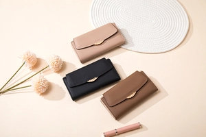 Three long PU leather wallets with golden leaf buckles in beige, black and brown colors