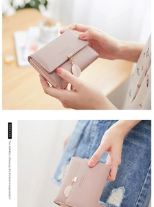 Detail of light pink PU leather tri-fold wallet with gold leaf pendant and snap closure