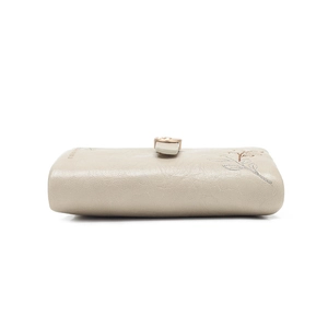 Detail of the champagne beige wallet featuring delicate leaf embroidery and a golden metal clasp