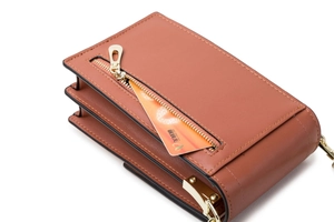 Close-up of brown faux leather shoulder bag featuring functional gold zipper and card slot