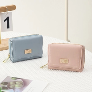 Detail of blue and pink PU leather mini wallets with gold flower accents and quilted pattern