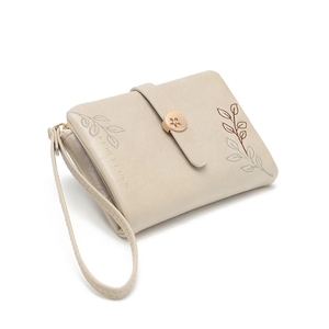 Close-up of beige leather wristlet wallet featuring elegant plant leaf embroidery detail