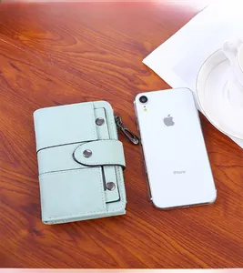 Short mint green PU leather wallet size comparison with a smartphone on wood