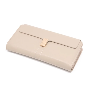 Detail of beige long wallet with leather texture, heart buckle and gold magnetic clasp