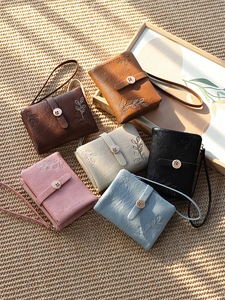 Detailed display of six colorful floral embroidered wallets with elegant gold flower buckles