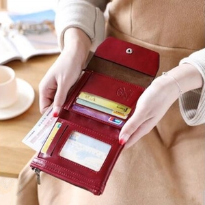 Interior detail of a red tri-fold PU leather wallet with card slots and zipper pocket