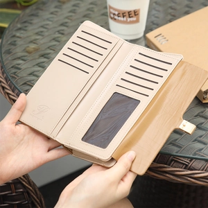 Close-up of beige leather long wallet with eleven card slots and gold buckle clasp