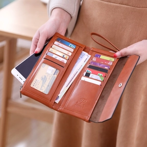 Brown leather long wallet detail showing multiple card slots and secure phone compartment