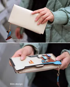 Slim off-white long wallet featuring cartoon dog patch and matching zipper charm detail