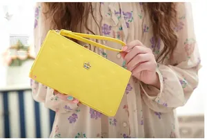 Detail of yellow PU leather wallet with crown logo embossing and jewel metal ornament