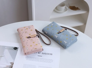 Close-up of pastel PU leather long wallets with forest cartoon prints and wrist straps
