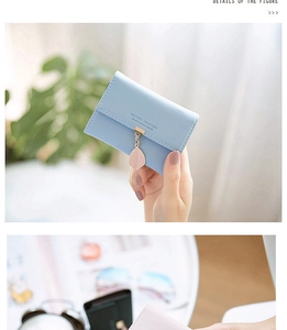 Close-up of light blue trifold card holder with gold clasp and pink leaf pendant
