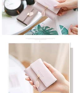 Detail of light pink PU leather wallet featuring a gold leaf pendant and trifold design