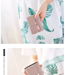 Close-up of pink PU leather tri-fold wallet with a gold leaf pendant detail