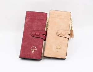 Detail of vintage long wallets with tassel pendants and gold metal umbrella accents