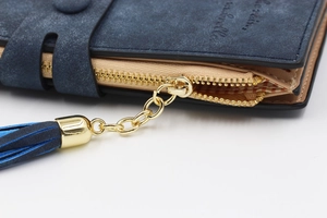 Macro shot of dark blue matte long wallet featuring gold zipper and stylish tassel detail