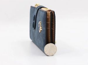 Detail view of deep blue matte wallet thickness with coin reference and crown charm