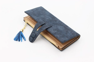 Detail of long multi-functional wallet featuring matte faux suede and tassel zip