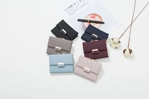 Close-up of short tri-fold PU leather wallet with grid texture and metal clasp closure