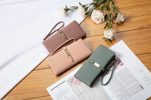Detail of elegant long wallets with metal ring hardware and wristlets in three colors
