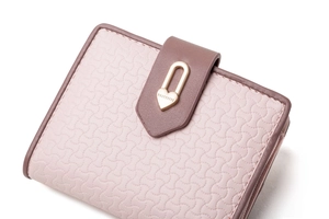 Dettaglio del portafoglio rosa con goffratura a onde e chiusura a cuore dorata