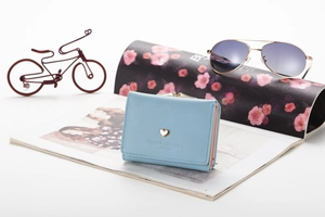 Detail of light blue tri-fold wallet with lychee grain leather and golden heart