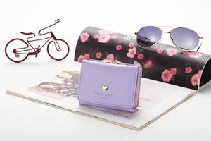 Macro detail of lavender tri-fold wallet with metal heart and Sweet Dream lettering