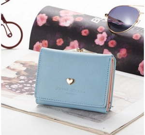 Close-up of light blue PU leather wallet with golden heart buckle and fine stitching