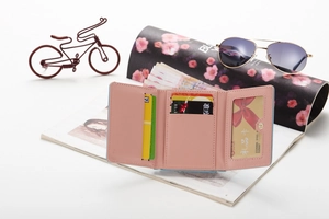 Interior detail of a trifold faux leather wallet showing card slots and ID window