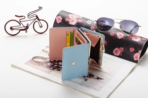 Detail of light blue tri-fold wallet showing multiple card slots and heart metal clasp