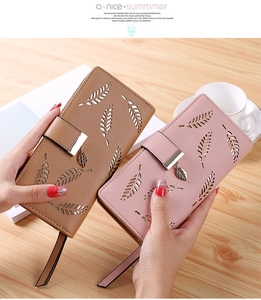 Close-up of long women's wallets with leaf cutout patterns and metal leaf charms