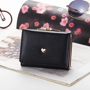 Black tri-fold PU leather women wallet with gold heart and vintage clasp on a magazine