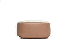 Detail view of the smooth rounded bottom on a cream and camel two-tone leather bag