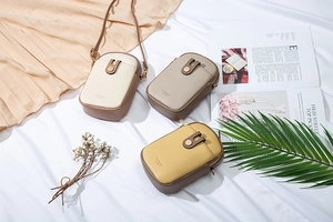 Vertical mini crossbody phone bags in three colors on a textured white fabric background