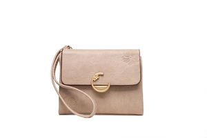 Detail of beige faux leather wallet featuring floral embossing and gold clasp with wristlet