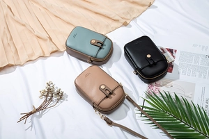 Detailed close-up of textured leather mini crossbody phone bags with metal hardware
