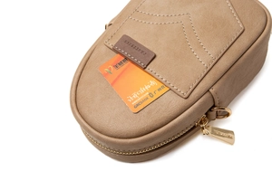 Detail showing the khaki PU leather texture and gold zipper of the mini phone bag