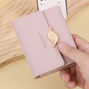 Close-up of light pink PU leather folding wallet featuring golden leaf clasp detail