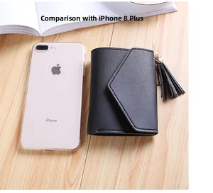 Black tassel wallet shown next to iPhone 8 Plus for size comparison on a wooden table