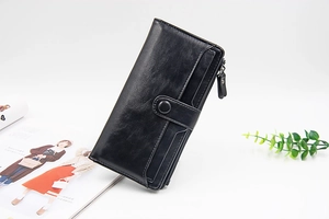 Dettaglio del portafoglio lungo in pelle nera con scomparti per carte e chiusura zip