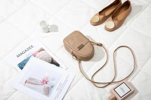 Vertical khaki crossbody phone bag with geometric stitching on a soft padded background