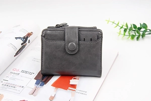 Detail of grey PU leather short wallet with vintage texture on a fashion magazine
