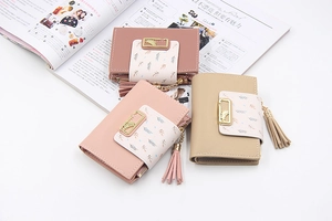 Close-up of PU leather mini wallets with leaf pattern, tassel zipper and metal hardware